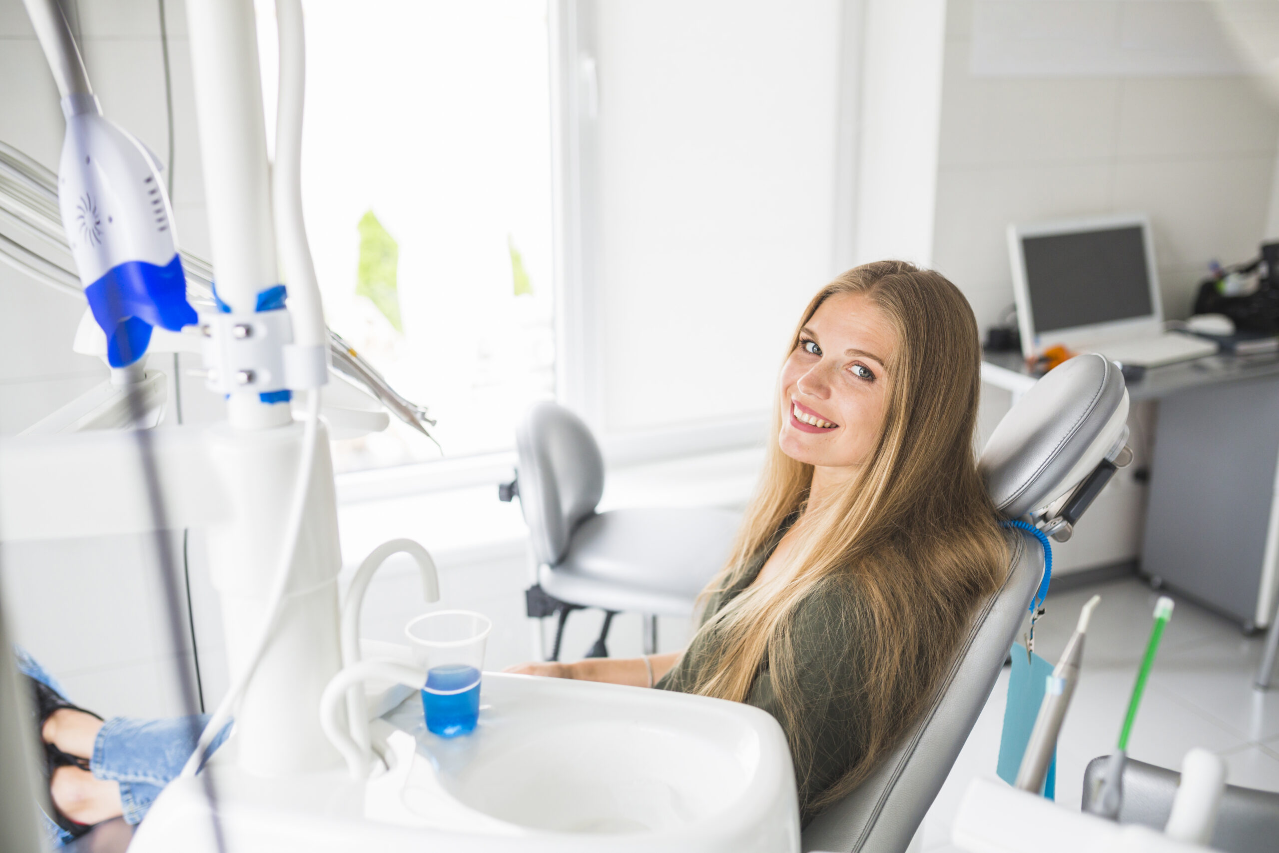 happy young woman sitting dental chair